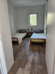 a room with two beds and a window at Guest House Karlobag - Villa Rose in Karlobag