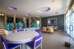 布希奧斯的住宿－Pousada Aroma do Mar by Latitud Hoteles，一间设有白色桌子和紫色椅子的用餐室