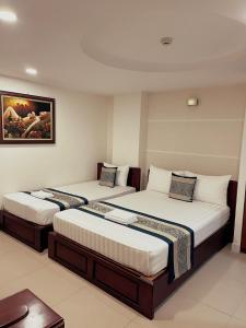 una habitación de hotel con 2 camas en una habitación en DINH DINH 2 AIRPORT HOTEL en Ho Chi Minh
