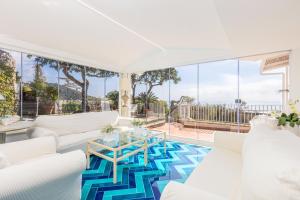 uma sala de estar com mobiliário branco e um tapete azul e branco em Villa Rita Apartments em Massa Lubrense