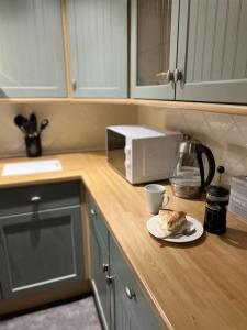 ein Stück Kuchen auf einem Teller auf einer Küchentheke in der Unterkunft Grand Mill: Near to Shops, Attractions, Restaurant in Burton upon Trent