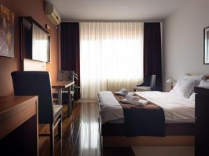 una camera d'albergo con letto, scrivania e finestra di Zlatna Ribica a Golubac