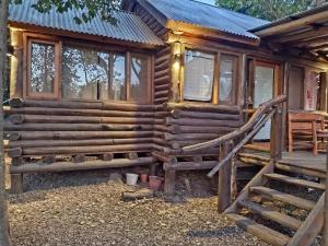 a log cabin with a staircase in front of it at Casal de Morgade in Villa Ciudad Parque