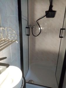 a shower with a glass door next to a toilet at la halte rando in Bangor