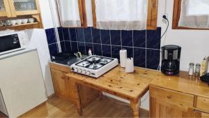 a kitchen with a stove and a wooden counter top at Veress Apartman Tusnádfürdő in Băile Tuşnad