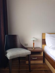 a bedroom with a chair next to a bed and a nightstand at Zlatna Ribica in Golubac