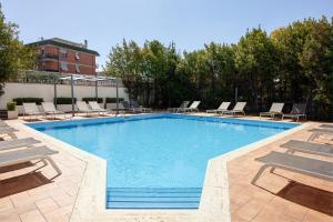 a large swimming pool with lounge chairs at Hotel Roma Tor Vergata in Tor Vergata