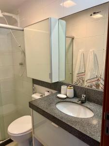 uma casa de banho com um lavatório, um WC e um espelho. em Carneiros Beach Resort - Flat 205-A em Praia dos Carneiros