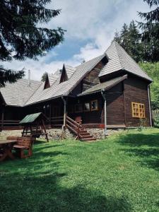 a log cabin with a picnic table in front of it at Veress Apartman Tusnádfürdő in Băile Tuşnad