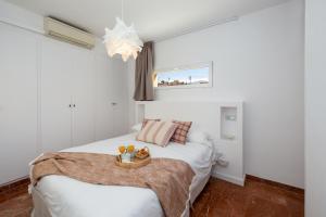 a bedroom with a bed with a tray of fruit on it at Gran Via Cathedral Apartment in Granada