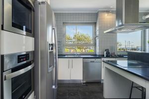 a kitchen with a refrigerator and a sink at Luxury Living by the Sea Matosinhos Marvel in Matosinhos