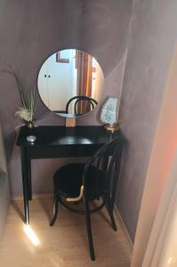 einen schwarzen Schreibtisch mit einem Spiegel und einem Stuhl in der Unterkunft Apartman Marija in Barban