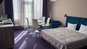 una camera d'albergo con letto, tavolo e sedie di Horizon Hotel a Odessa