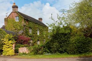 an old brick house covered in ivy at Finest Retreats - Nether Burrows Farm in Ashbourne