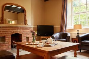 a living room with a table and a fireplace at Finest Retreats - Nether Burrows Farm in Ashbourne