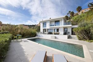 a swimming pool in the backyard of a house at Sunnydaze, 4 bed V/F pool villa in Villefranche-sur-Mer