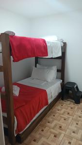 a bedroom with two bunk beds with red and white sheets at APARTAMENTO TURISTICO SALENTO QUINDIO R. in Salento