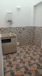 a kitchen with a counter and a tile floor at APARTAMENTO TURISTICO SALENTO QUINDIO R. in Salento