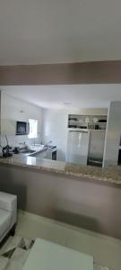 a kitchen with a counter and a kitchen with appliances at Casa 109 COND BRISAS DO FAROL n 07 in Salvador