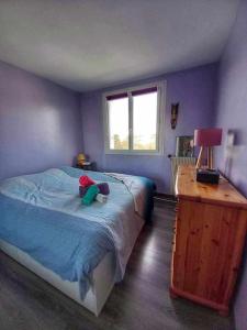 un dormitorio con un osito de peluche sentado en una cama en Appartement familial F3, proche Disney, avec parking, en Lagny