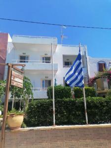 a blue and white flag in front of a building at Ambrosia studios in Makry Gialos