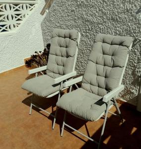 two chairs sitting next to each other in front of a wall at 200 m playa, WiFi, TV SAT, BBQ in Pilar de la Horadada