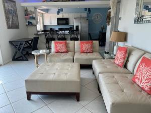 a living room with two couches and a kitchen at Ocean Front in Cocoa Beach in Cocoa Beach