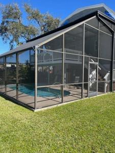 uma grande casa de vidro com uma piscina em South Venice Balcony Fun House em Venice