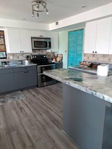 a kitchen with white cabinets and a counter top at South Venice Balcony Fun House in Venice