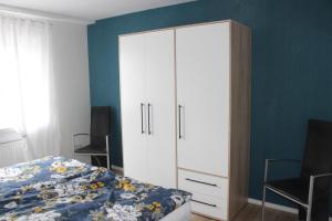 een slaapkamer met een grote witte kast en een bed bij NEU! Ferienwohnung Nickel in Ahausen