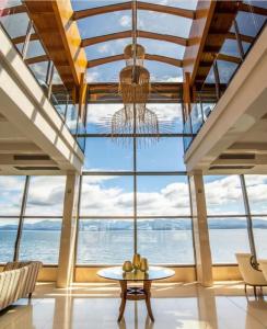 una grande camera con tavolo e lampadario a braccio di Alma Del Lago Suites & Spa a San Carlos de Bariloche