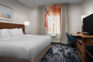 a hotel room with a bed and a desk and a television at Fairfield Inn & Suites by Marriott Panama City Beach in Panama City Beach