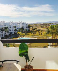 a view of a park from a balcony with a plant at Cosy Top-Floor Sunny Apartment with Balcony, Stunning Golf Resort Views,Proximity to Swimming Pool and Kids Playground, Only 20min to the Beach in Roldán