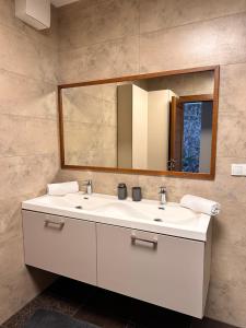 a bathroom with a white sink and a mirror at Apartmán Leonardo - city center in Trnava
