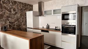 una cucina con elettrodomestici bianchi e piano di lavoro in legno di Apartmán Leonardo - city center a Trnava