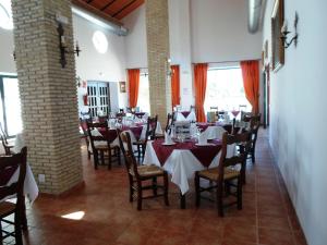 a restaurant with tables and chairs in a room at Complejo Pueblo Blanco in Olvera