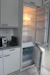 een keuken met een lege koelkast met open deur bij NEU! Ferienwohnung Nickel in Ahausen