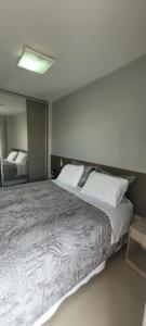 a bedroom with a large bed with a mirror at Casa 109 COND BRISAS DO FAROL n 07 in Salvador