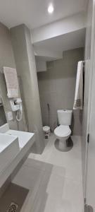 a white bathroom with a toilet and a sink at Casa 109 COND BRISAS DO FAROL n 07 in Salvador +8 photos