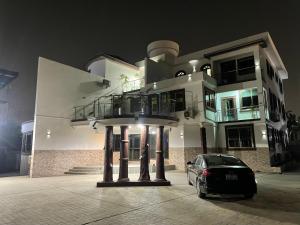 een auto geparkeerd voor een huis 's nachts bij JD Hotel And Bar. in Accra