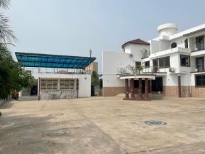 een groot wit gebouw met een grote parkeerplaats bij JD Hotel And Bar. in Accra