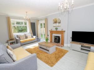 a living room with a fireplace and a tv at Morningside in Totland