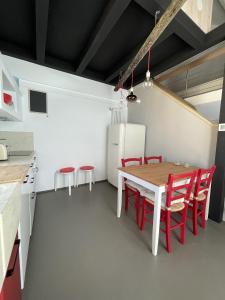 eine Küche und ein Esszimmer mit einem Tisch und roten Stühlen in der Unterkunft Angolo sul Porto in Brenzone sul Garda