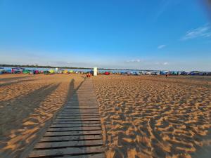 a beach with a wooden pathway in the sand at Alojamiento Ibirá in San José