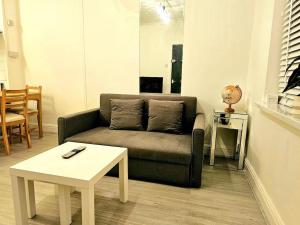 a living room with a couch and a table at Modern & Cosy 1 bedroom flat in Bridgend