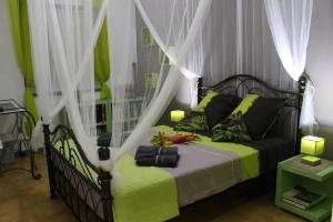 a bedroom with a green bed with a canopy at chambre et table d’hôte au Diamant in Le Diamant
