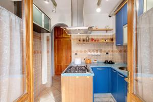 cocina pequeña con armarios azules y fogones en La Maison des Jumeaux, en Châtillon