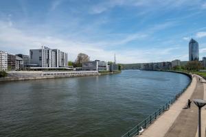 a river in a city with buildings in the background at Van der Valk Hotel Li&egrave;ge Congres in Li&egrave;ge
