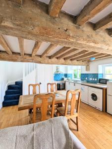 a kitchen and dining room with a wooden table and chairs at Kingfisher Barn in Abingdon +16 photos
