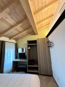 een slaapkamer met een bed, een bureau en een houten plafond bij Saragozza Suite 7 Attico con altana a due passi da Piazza Grande WIFI e parcheggio gratuito in Modena